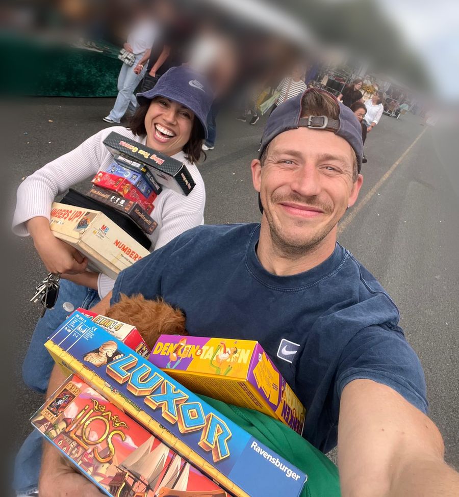 Tamara met armen vol bordspellen op de markt